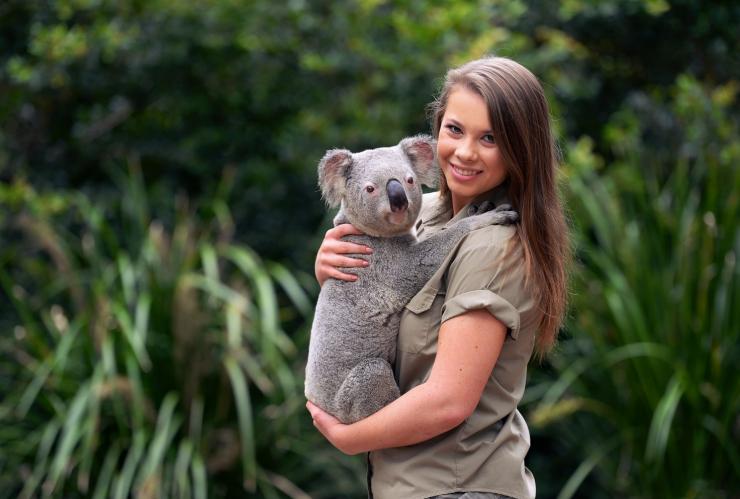 Bindi Irwin stands cuddling a koala at Australia Zoo, Sunshine Coast, Queensland © Australia Zoo