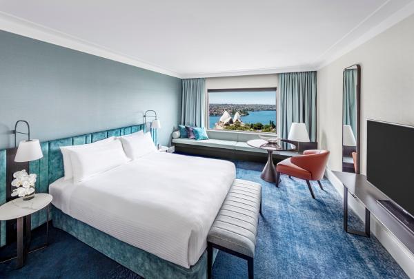A stylish hotel room styled in cool blue tones offers harbour and Sydney Opera House views, operated by InterContinental Sydney, at InterContinental Sydney, Sydney, New South Wales. © InterContinental Sydney
