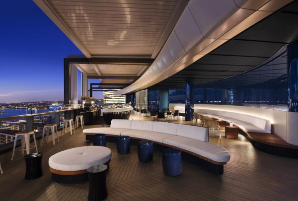 Sleek lounge seating frames views of the glowing city sky at dusk from Zephyr bar, Hyatt Regency, Sydney, New South Wales. © Geoff Lung