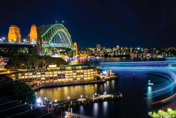 A long-exposure view of light trails across Sydney Harbour, showing the illuminated Harbour Bridge and water near Park Hyatt Sydney, New South Wales. © Destination NSW