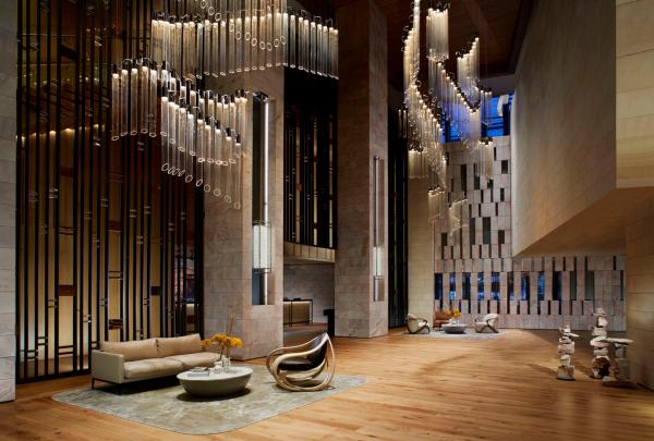 An expansive, high-ceilinged hotel lobby features sophisticated seating lounges beneath spectacular cascading glass pendant lights, The Ritz-Carlton, Perth, Western Australia. © Christopher Cypert