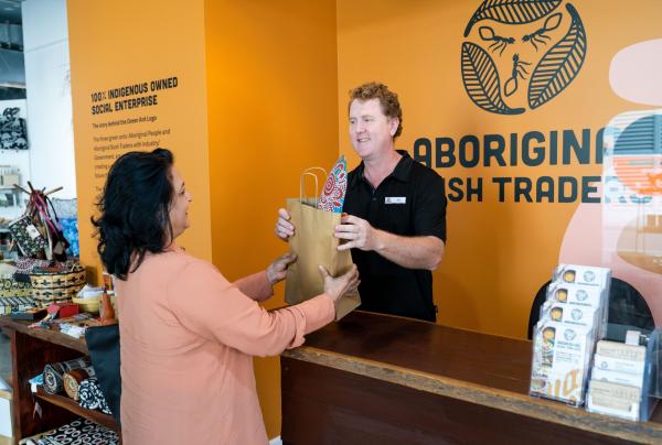 Woman purchasing an item at Aboriginal Bush Traders, Darwin, Northern Territory © Tourism Australia