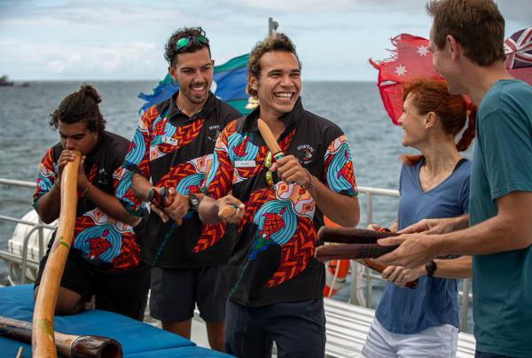 Indigenous guides share traditional music with passengers aboard a Dreamtime Dive and Snorkel boat on the Great Barrier Reef, Cairns, Queensland. © Tourism and Events Queensland