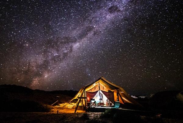 A glowing safari tent sits nestled beneath a starry night sky and the Milky Way at Sal Salis, Cape Range National Park, Western Australia. © Sal Salis