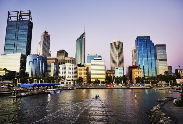 A boat creates a wake across the dark waters of Elizabeth Quay as dusk falls over the glowing Perth city skyline, Western Australia. © Dianna Snape