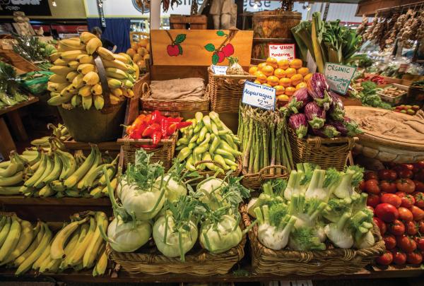 A vibrant display of fresh bananas, eggplants, asparagus, and fennel is neatly arranged in baskets at Adelaide Central Market, Adelaide, South Australia. © Tourism Australia