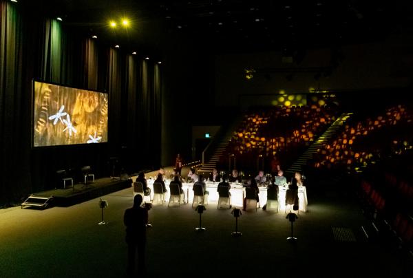 Guests dine at a illuminated table on stage during the Seven Seasons dining experience at Darwin Convention Centre, Darwin, Northern Territory. © Darwin Convention Centre