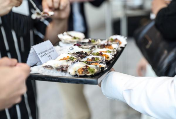 A server presents a tray of freshly dressed oysters on ice to guests at ICC Sydney, Sydney, New South Wales. © ICC Sydney