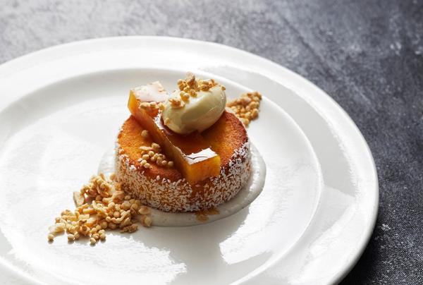 An elegantly plated dessert features a round citrus cake topped with fruit gel, cream, and toasted nuts at Melbourne Convention and Exhibition Centre, Melbourne, Victoria. © Melbourne Convention Exhibition Centre