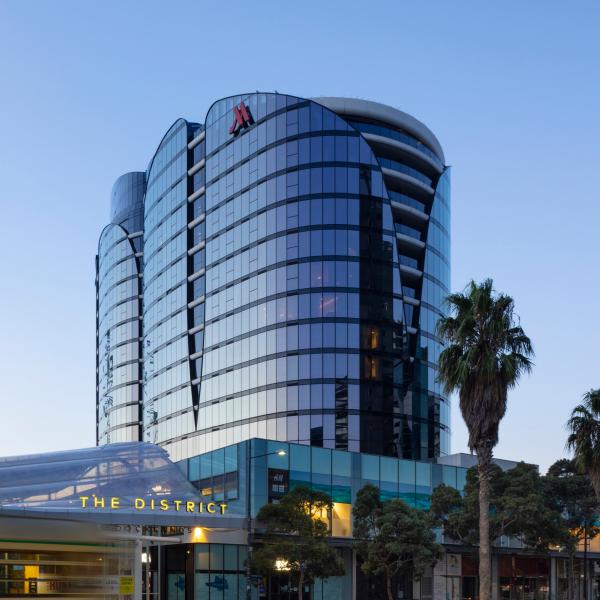 A sleek glass high-rise tower reflects the soft twilight sky beside a tram stop in Docklands, Melbourne Marriott Hotel Docklands, Melbourne, Victoria. © Dianna Snape