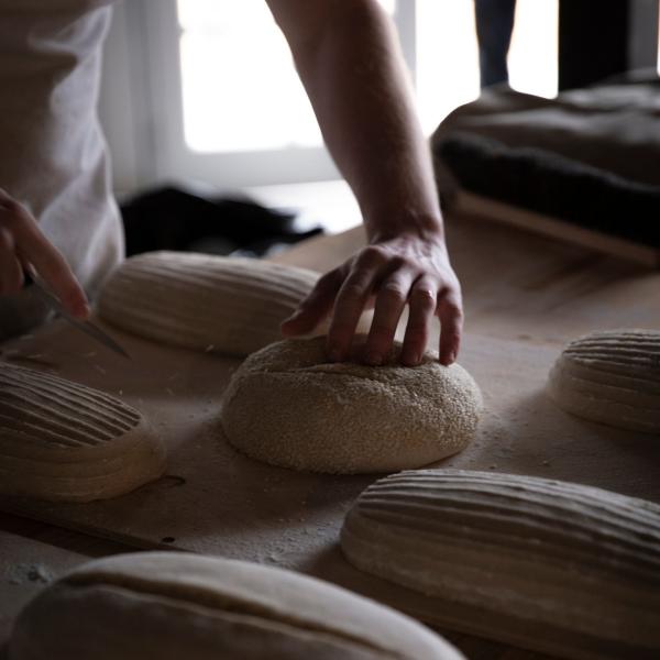 A baker scores artisanal sourdough bread loaves prior to baking at Lake House Daylesford, Victoria. © Lake House Daylesford