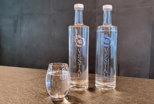 Two clear glass Vestal water bottles and a filled glass rest on a dark stone counter at the Perth Convention and Exhibition Centre, Perth, Western Australia.© Perth Convention and Exhibition Centre
