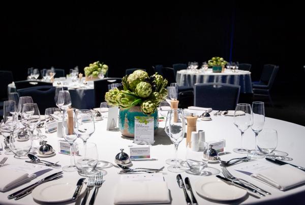 Elegantly dressed banquet table with fine glassware, cutlery, and an artichoke centrepiece setup for a function at the ICC Sydney, Sydney, New South Wales. © ICC Sydney