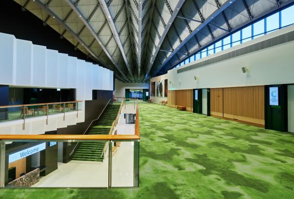 Bright, open foyer with patterned green carpet, sleek wooden panelling and a dramatic vaulted ceiling at Cairns Convention Centre, Cairns, Queensland. © Tourism Australia