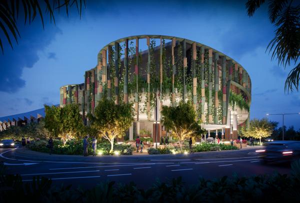 A striking curved facade draped in lush tropical greenery glows brightly at dusk above landscaped gardens, Cairns Convention Centre, Cairns, Queensland. © Cairns Convention Centre