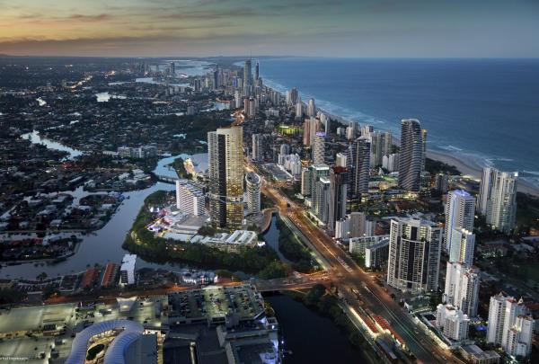An aerial twilight view reveals The Star hotel tower and resort complex nestled along winding waterways near the coastal skyline, Gold Coast, Queensland. © The Star