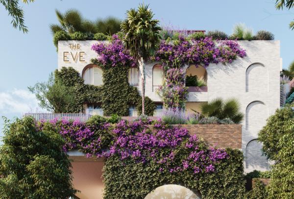 Lush green vines and vibrant purple bougainvillea drape over the stylish facade and arched windows of The Eve Hotel in Sydney, New South Wales, featuring a distinct circular cut-out wall. © TFE Hotels