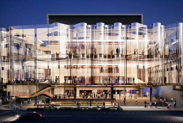 Architectural rendering of Queensland Performing Arts Centre in Brisbane, Queensland, featuring a glowing glass façade revealing multi-level foyers filled with patrons under a night sky. © Queensland Performing Arts Centre