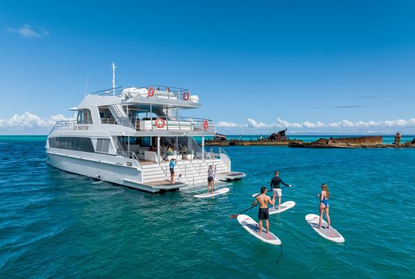 The Spirit of Mulgumpin at the Tangalooma Wrecks showing guests paddling boarding and relaxing on board © See Moreton