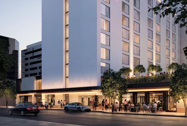 The sleek white exterior of Hyde Perth in Western Australia features a glowing pink neon sign on the facade. At dusk, people gather at the ground-floor restaurant and outdoor terrace tables lining the city street. © Hyde Perth
