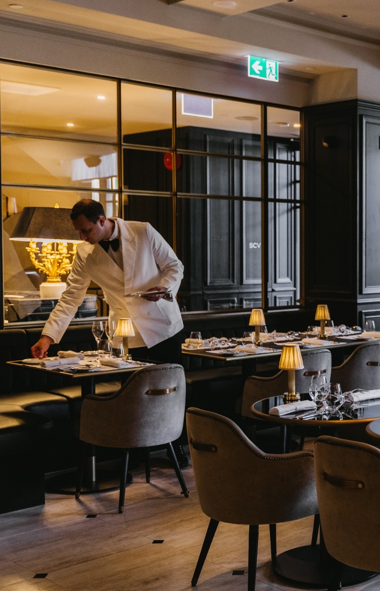 A waiter sets a table in the restaurant Maison Bâtard © Liana Hardy A waiter sets a table in the restaurant Maison Bâtard © Liana Hardy