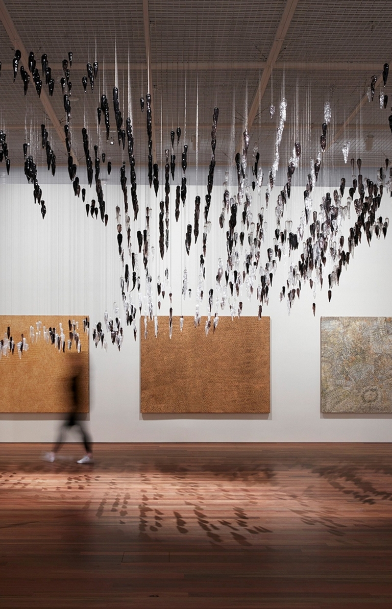 Installation view of the Yiribana Gallery featuring Gallery featuring (from left) YukultjiNapangati 'Untitled' 2005, DoreenReid Nakamarra 'Untitled' 2007,Bobby West Tjupurrula 'Tingari sites around Kiwirrkura' 2015 and RonnieTjampitjinpa 'Tingari fire dreaming at Willinkkarra' 2008, and (top) Yhonnie Scarce 'Death zephyr' 2017 © Ken Leanfore