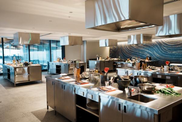A large teaching kitchen with stainless steel benches set up as cooking stations with instructions and ingredients © Sydney Seafood School