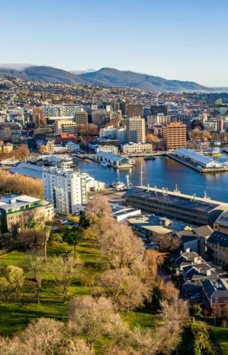 An aerial view of Hobart Harbour reveals the Institute for Marine and Antarctic Studies alongside the CSIRO, sitting prominently by the water. In the background, Salamanca, Elizabeth Street Pier, and Constitution Dock bustle with activity. © Tourism Australia