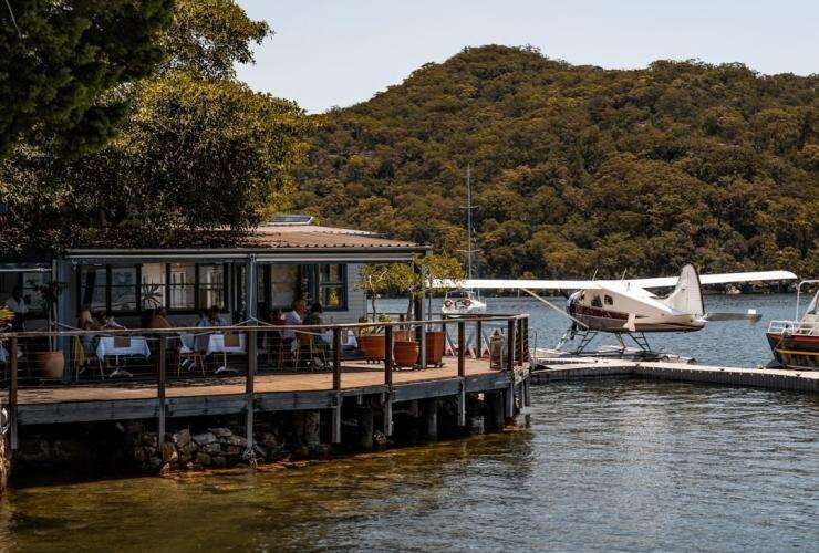 Sydney Seaplane parked in the water beside Cottage Point Inn, located on the edge of Ku-ring-gai Chase National Park © Sydney Seaplanes