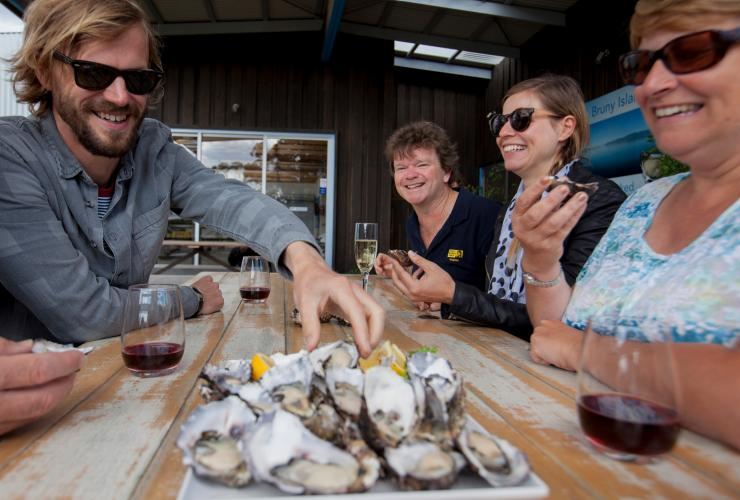 A group tucks into freshly shucked oysters on the Bruny Island Traveller Tour, Tasmania © Hype TV and Aerial Vision Australia A group tucks into freshly shucked oysters on the Bruny Island Traveller Tour, Tasmania © Hype TV and Aerial Vision Australia