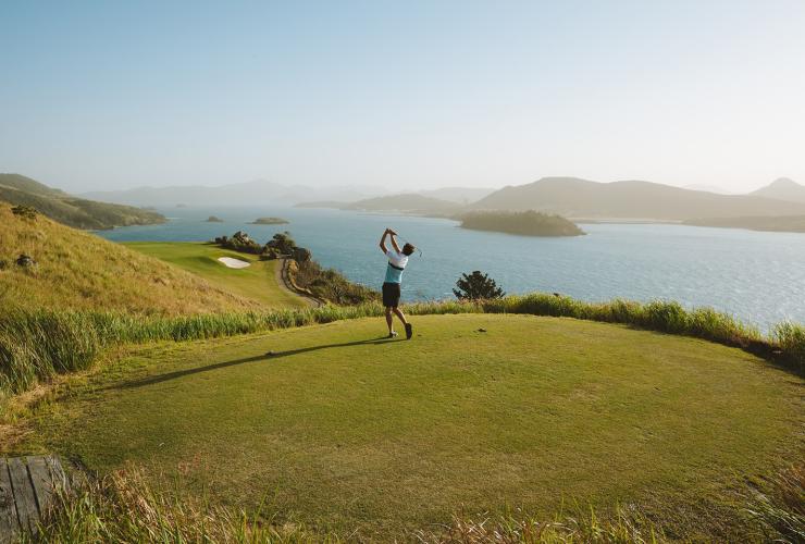People playing golf on the Hamilton Island Golf Course on Dent Island with the Whitsunday Islands in the background © Tourism Australia