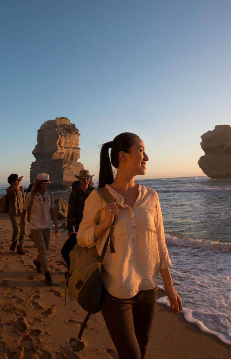 A group walks on the beach admiring the Twelve Apostles, Victoria © Tourism Australia