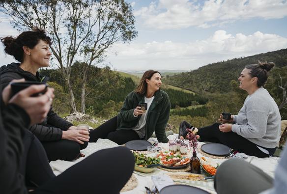 The group enjoys a chef prepared picnic overlooking hills in the Barossa © Barossa Helicopters