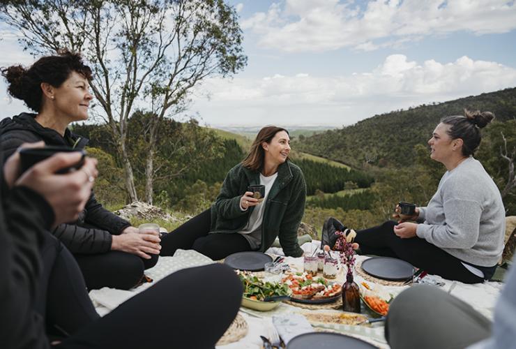 The group enjoys a chef prepared picnic overlooking hills in the Barossa © Barossa Helicopters