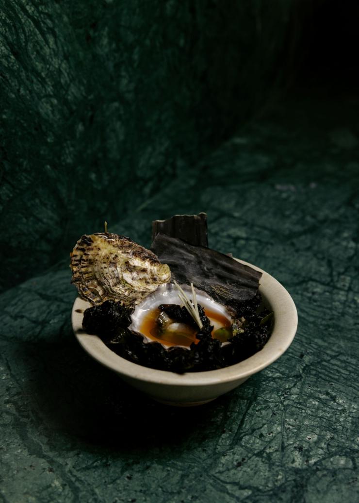 A plated dish of seafood and seaweed sits on the the green marble counter, Yakisan, Adelaide, South Australia © Yakisan