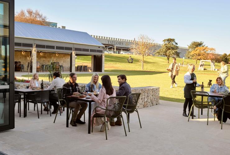 The cellar grounds showing a terrace with people seated and lawn at Taylors Wines, Clare Valley, South Australia © Taylors Wines