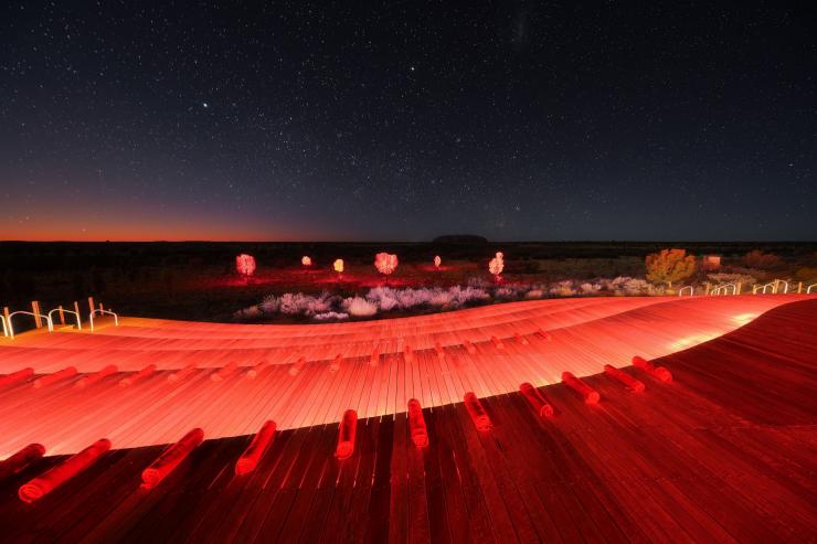 The events platform at Ayers Rock Resort waiting for guests to arrive for the Sunrise Journeys experience with coloured desert projects, a starry sky and Uluṟu in the background, Northern Territory © Matt Lambley