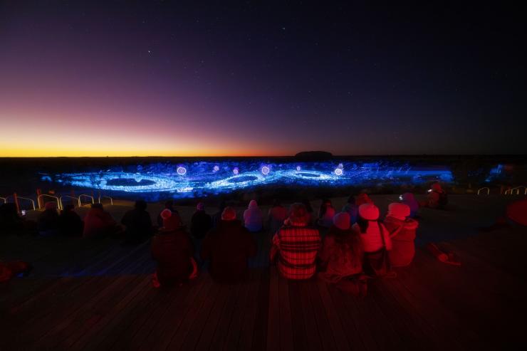 Guests rugged up for the cool desert mornings watch the Sunrise Experience, Northern Territory © Matt Lambley