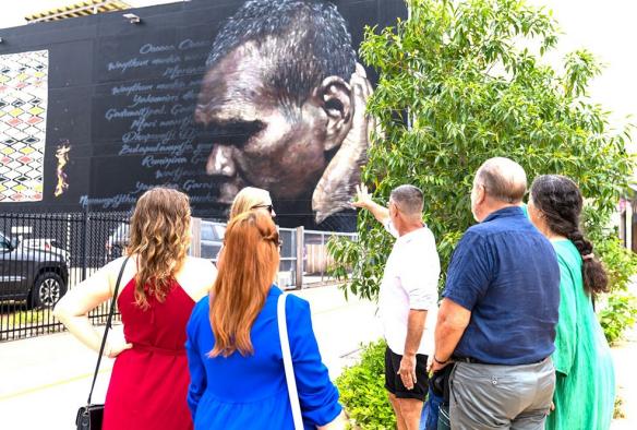 A tour group observes a mural of Indigenous Australian Gurrumul in Darwin, Northern Territory © Darwin Gourmet Tour