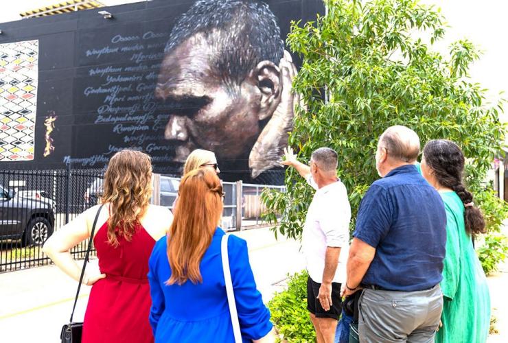 A tour group observes a mural of Indigenous Australian Gurrumul in Darwin, Northern Territory © Darwin Gourmet Tour