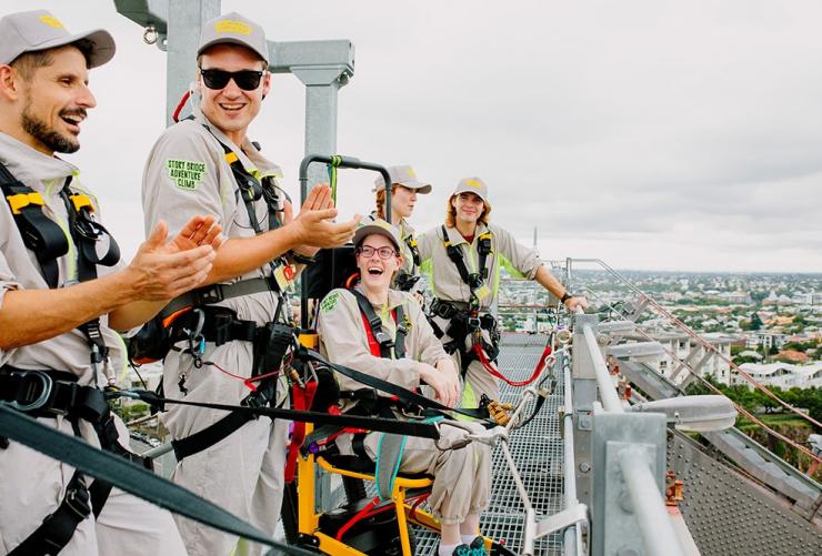 A group applauds as they reach the top of Story Bridge on the Accessible Bridgeclimb experience, Brisbane, Queensland © Story Bridge Adventure Climb