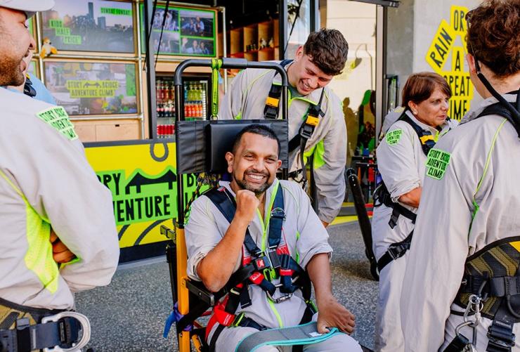 Strapping into the custom designed stairclimber chair in preparation for the Story Bridge Accessible Bridgeclimb, Brisbane, Queensland © Story Bridge Adventure Climb