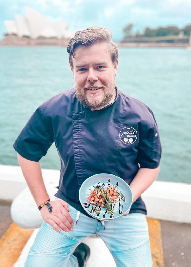 Matt Atkins, Owner and Executive chef with a plate of seafood and the Sydney Opera House in the background, Sydney, New South Wales © Plate Hospitality Group