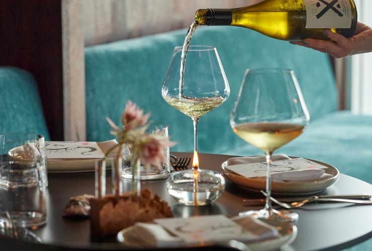 Wine is poured at the table with turquoise seats at Pearla&Co © Frances Andrijich