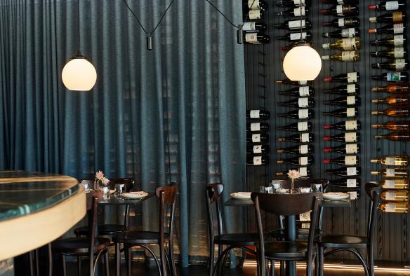 The wine wall at Pearla&Co, partially covered with a sheer blue curtain © Frances Andrijich