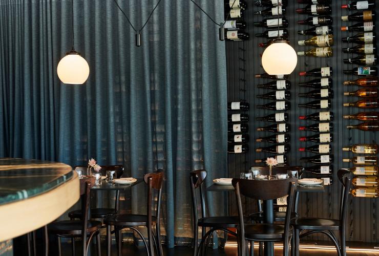 The wine wall at Pearla&Co, partially covered with a sheer blue curtain © Frances Andrijich