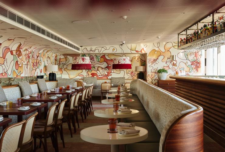 The indoor space of Moncia with a view of the bar, showing the Banquette seating wrapping the tabled area of the indoor space. © Steven Woodburn