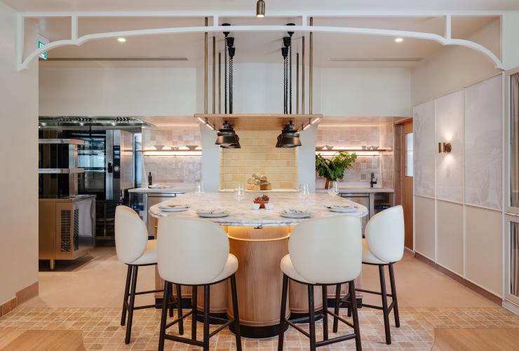 An extendable marble table setting, with a woodfire opening and four bar chairs for tastings © Adam Gibson