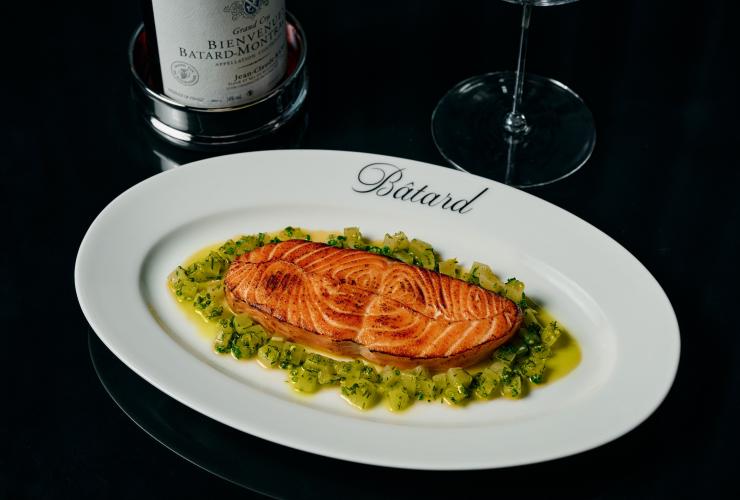 A Bâtard dish with a confit of salmon and diced vegetables and a bottle of wine. © Maison Bâtard