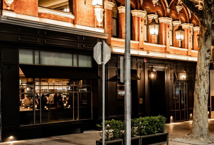 The exterior of Maison Bâtard showing a dark exterior on ground level and red brick exterior © Alex Drewniak  